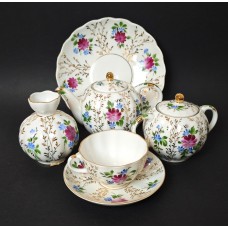 Under the sofa in the large room (with a biscuit box and vase).